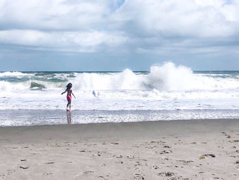 Girl on beach against sky