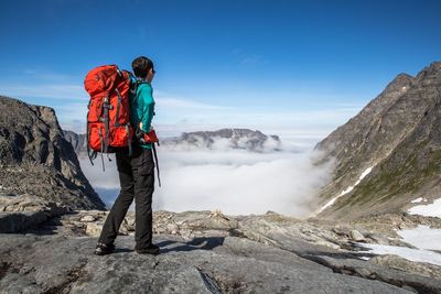 Person on mountain against blue sky