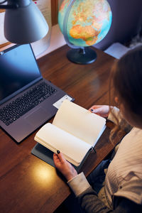 Student learning remotely from home. young woman making notes, reading and learning