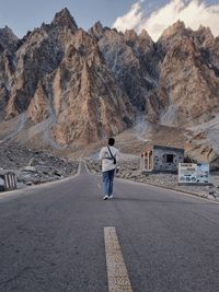 Rear view of man walking on the karakoram highway, pakistan 