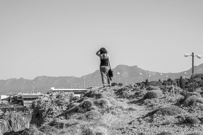 Rear view of woman standing on field against clear sky in cyprus