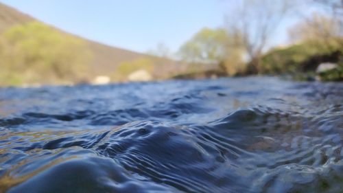 Close-up of water flowing in sea against sky