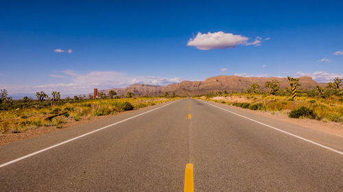 Empty road along landscape against sky