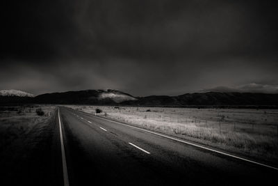 Country road against cloudy sky