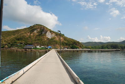 Scenic view of lake by mountains against sky