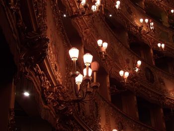 Low angle view of illuminated chandelier hanging in building