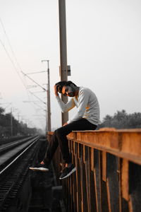 Man standing on railroad track against sky