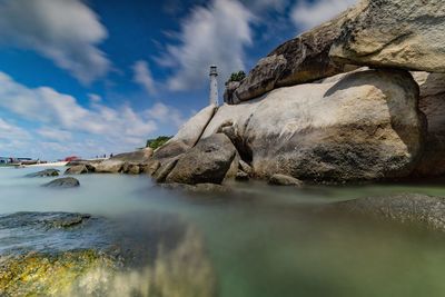 Rock formation in sea against sky