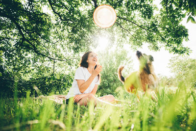 Side view of woman sitting on field