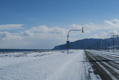 Snow covered road against sky