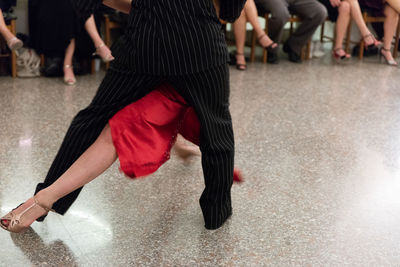Low section of dancers dancing on tiled floor