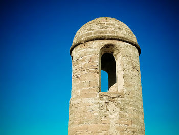 Low angle view of old ruin building against blue sky