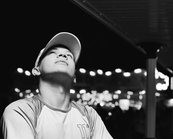 Man looking up against sky at night