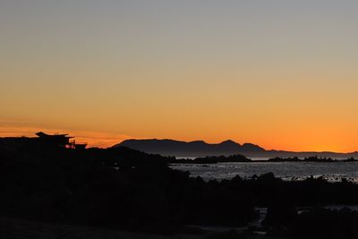 Scenic view of silhouette mountains against romantic sky at sunset