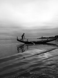 Silhouette man on boat against sky