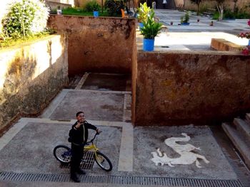 Man riding bicycle on footpath in city