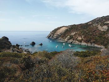 Scenic view of sea and mountains against sky