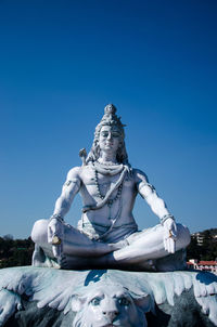 Low angle view of statue against clear blue sky