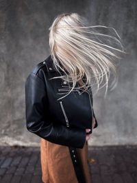 Midsection of woman standing against wall