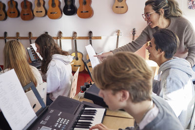 Teenagers and teacher during keyboard lesson