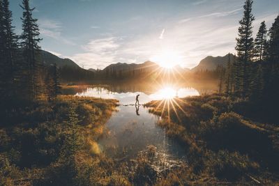 Person walking over lake at dawn