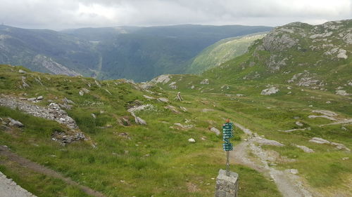 Rear view of man standing on mountain against sky