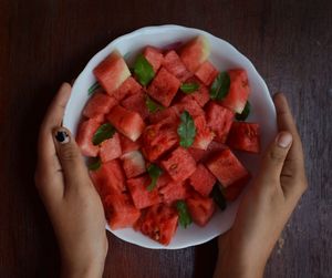 Directly above shot of person holding strawberry on table