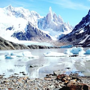 Scenic view of snow covered mountains against cloudy sky