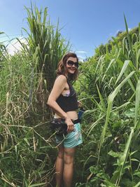 Young woman wearing sunglasses amidst plants on field