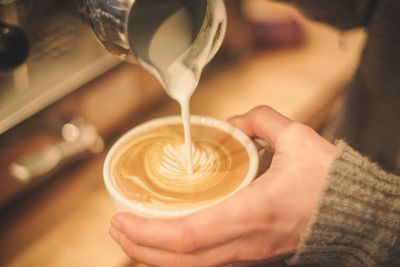 Close-up of woman making froth art