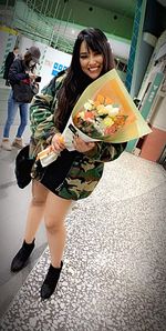 Portrait of smiling young woman holding umbrella