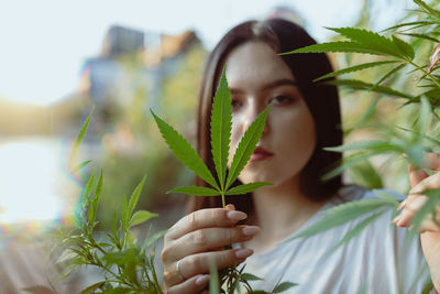 Portrait of young woman amidst plants