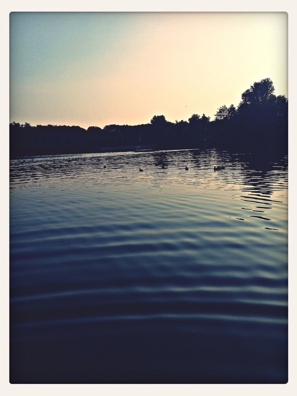 transfer print, water, reflection, auto post production filter, lake, tranquil scene, clear sky, tranquility, scenics, beauty in nature, waterfront, silhouette, nature, copy space, sunset, rippled, idyllic, sky, calm, outdoors