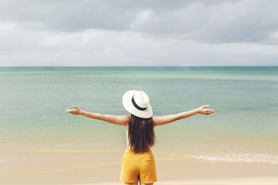 Woman looking at sea against sky