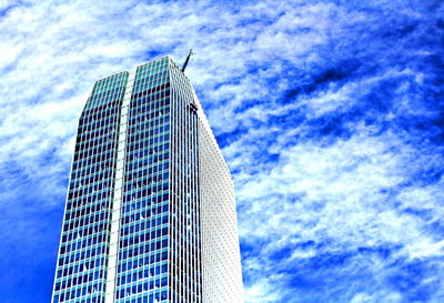 Low angle view of modern building against cloudy sky