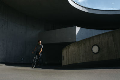 Man riding bicycle on bridge