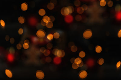 Abstract blurred shiny bokeh light up black background. defocused golden lights.