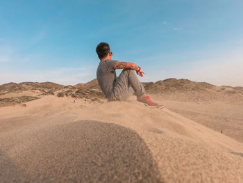 Man sitting on rock in desert