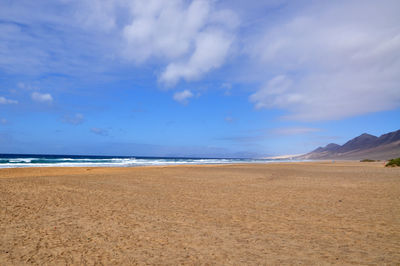 Scenic view of sandy beach against sky