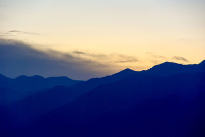 Scenic view of silhouette mountains against sky at sunset