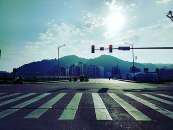 Road sign on street in city against sky