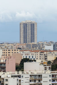 Buildings in city against cloudy sky