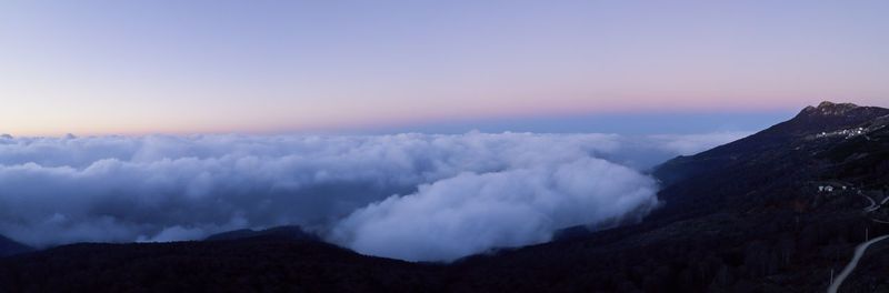 Smoke emitting from volcanic mountain against sky during sunset