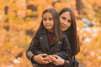 Portrait of a smiling young woman with autumn leaves