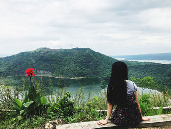 Rear view of woman looking at mountains against sky