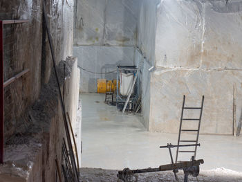 Marble quarry with a ladder and other working tools inside the mountain in carrara, tuscany - italy.