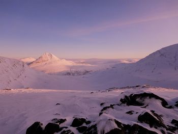 Scenic view of snowcapped mountains against sky during sunset