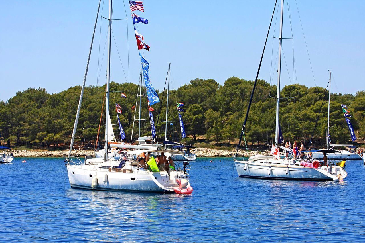 BOAT SAILING IN SEA AGAINST CLEAR SKY