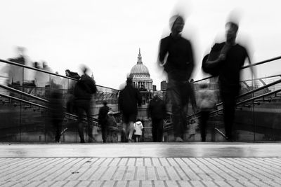 People walking on bridge leading towards st paul cathedral