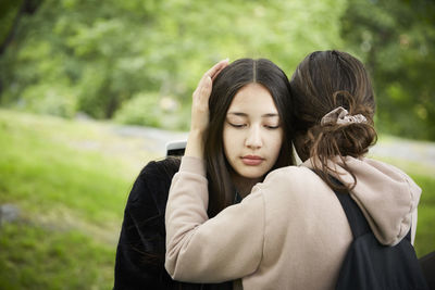Teenage girl consoling female friend